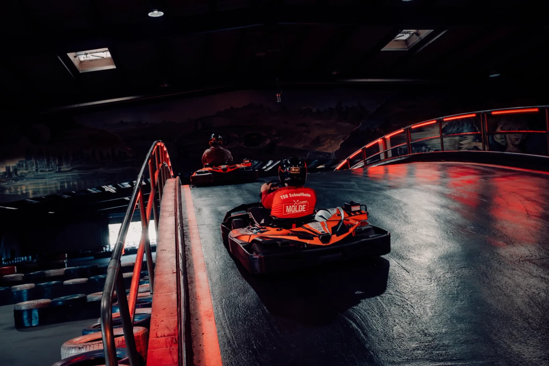 Eine Gruppe fährt mit den Karts über die Brücke der Indoor-Strecke